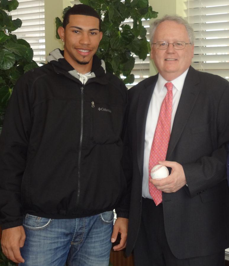 Junior Jhonneris Mendez (left), who was recently named NCAA Division III Pitcher of the Week presents President James McCarthy with an autographed ball.