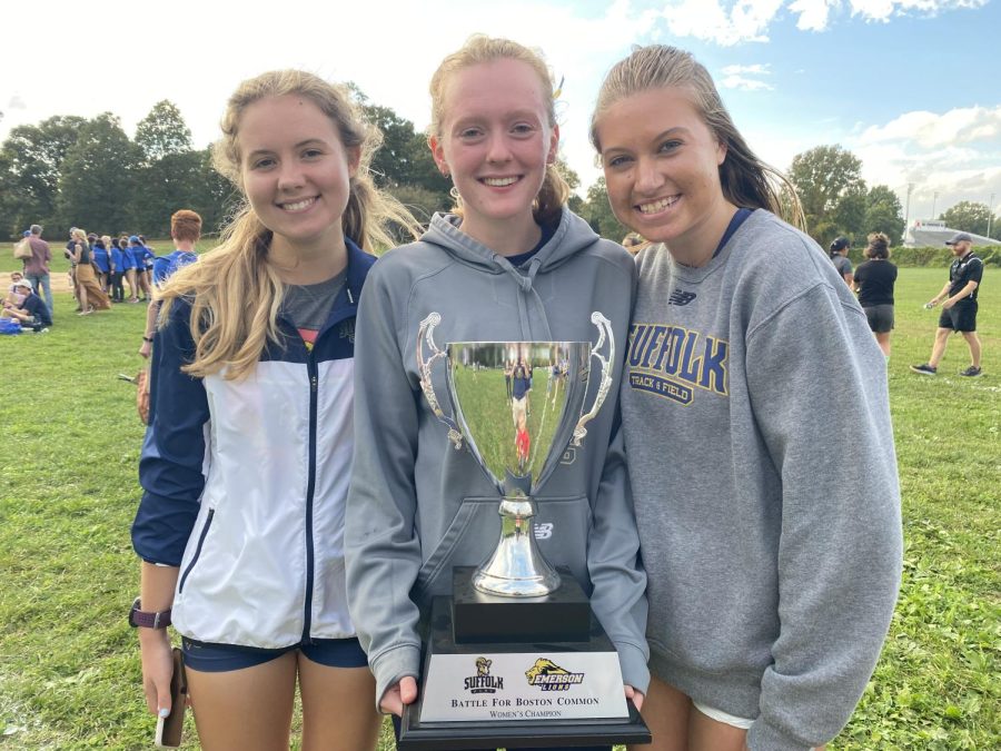 Members of the womens cross country team pose with the Battle for the Common Trophy