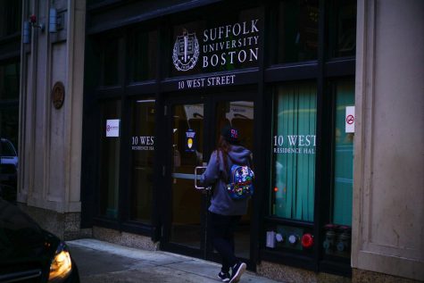 A student walks into Suffolk Universitys 10 West residential building.