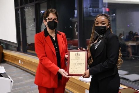  President Marisa Kelly (left) and Tumi (right) pictured with the Creating the Dream award. Photo credit_ Michael J. Clarke, University photographer