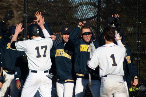 Suffolk baseball celebrates after scoring a run against MIT on Tuesday afternoon