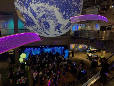 Students dance under a replica of the world at the Museum of Science.