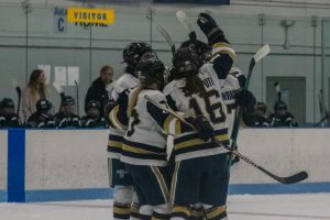 Members of the womens hockey team celebrate after a goal.