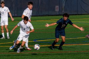 Sophomore midfielder Miguel Varela looks for a yellow card from the referee after being tripped late in the Commonwealth Coast Conference championship at Roger Williams University on Nov 5. This was a crucial point, as the Rams had closed their deficit to 2-1, and was putting heavy pressure on the Roger Williams defense. The no-call allowed Roger Williams to take control of the ball until time expired, securing their 2-1 victory.