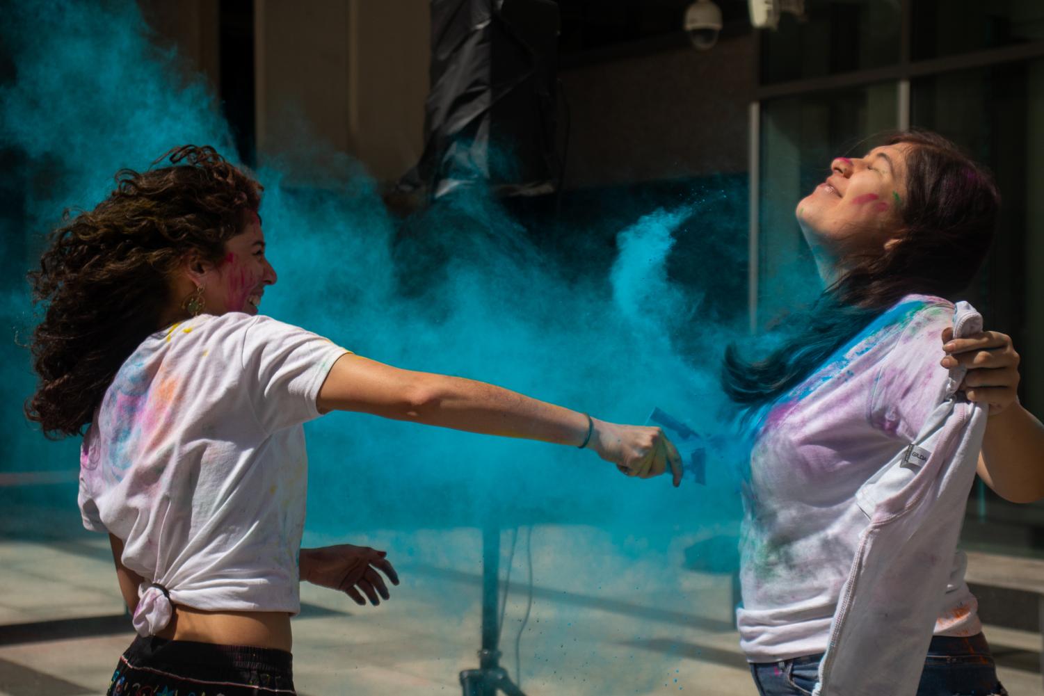 Students celebrate Holi with vibrant colored powder in Roemer Plaza. 