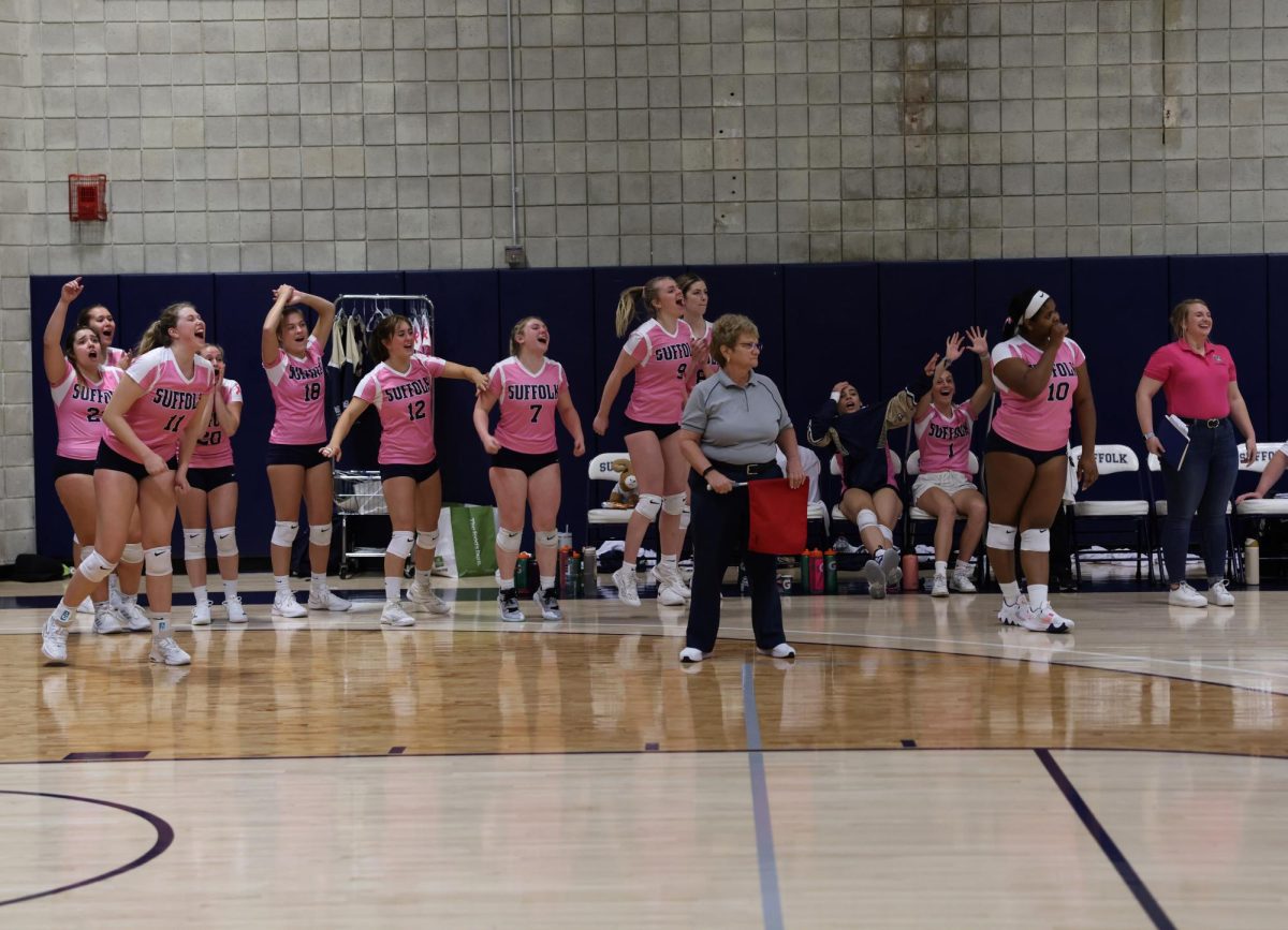 The Suffolk University volleyball team celebrates from the bench in a matchup against Curry College Oct. 3. The Rams won the game in a 3-0 sweep. 