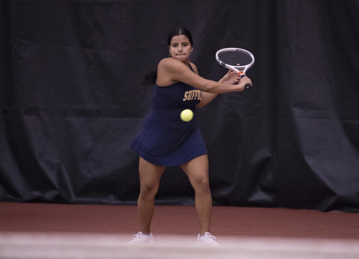 Senior Caren Urbano winds up to hit the ball during a match against Salve Regina University on Oct. 8, 2022.