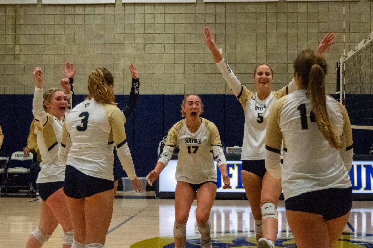 Junior outside hitter McKenna Keowen gets fired up as the rest of the volleyball team celebrates a point during a 3-0 shutout over Roger Williams University Oct. 18. Keowen had 16 kills in the match, held at Larry E. Smith and Michael S. Smith Court in Suffolks Ridgeway Building.