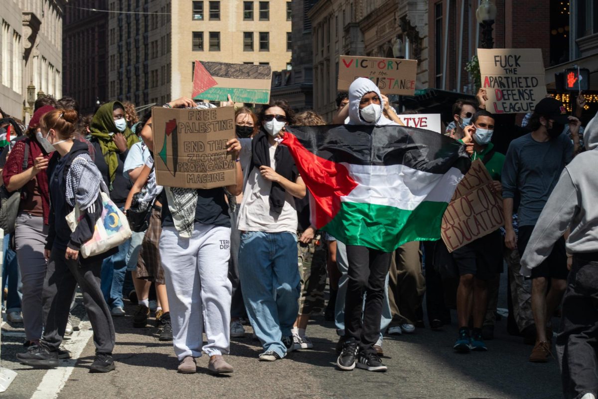 Suffolk and Emerson students march outside 73 Tremont, calling for universities to divert from Israel affiliations.