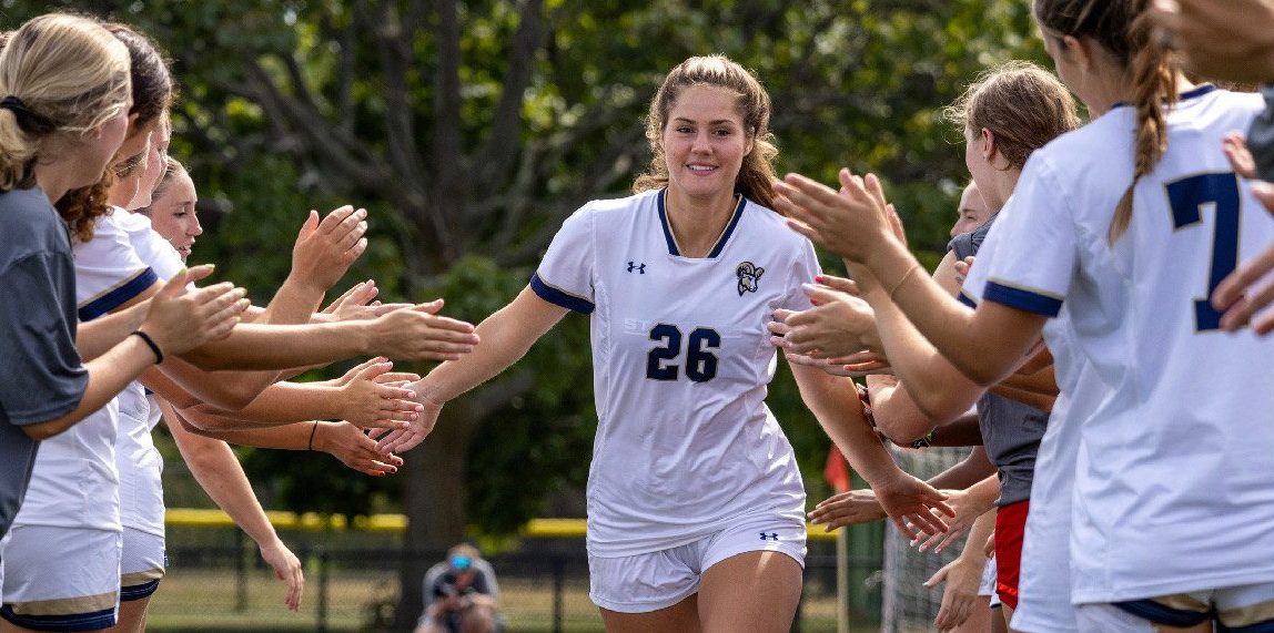 Freshman midfielder Sinclaire Hart running through the high five line before a game.