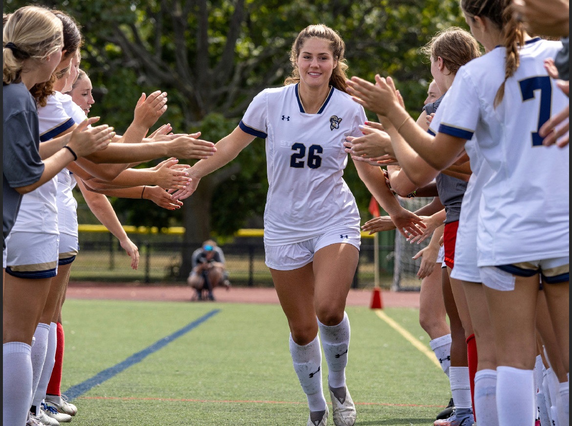 Freshman midfielder Sinclaire Hart running through the high five line before a game.