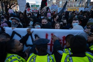 Boston Police officers push back against counter-protesters in Copley Square Saturday. Two sides clashed as anti-abortion march drew hundreds of dissenters to downtown Boston.