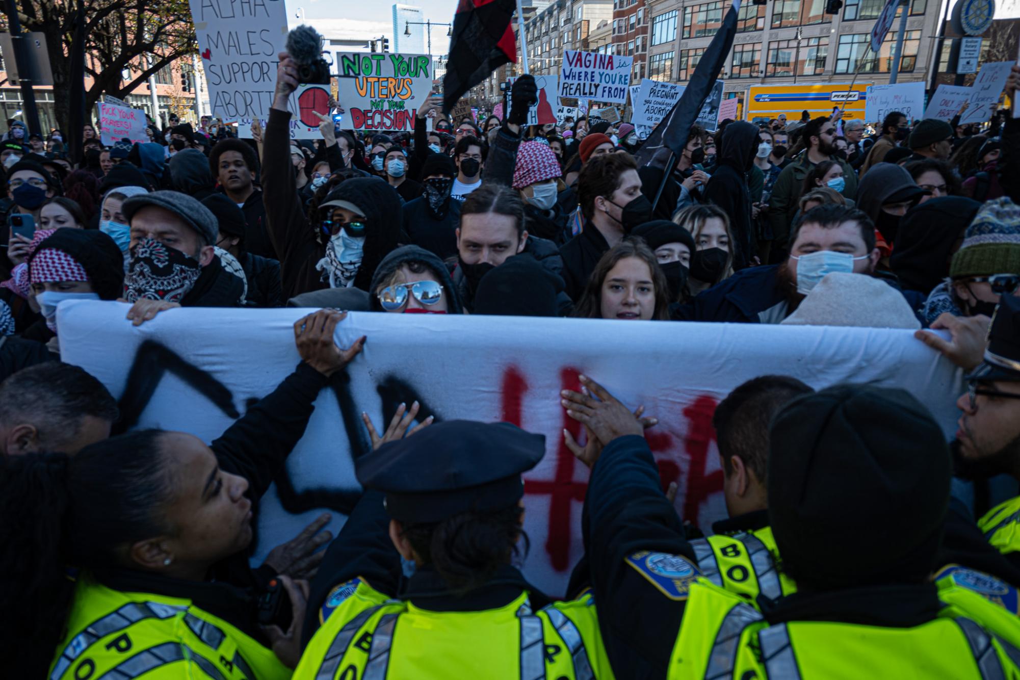 Boston Police officers push back against counter-protesters in Copley Square Saturday. Two sides clashed as anti-abortion march drew hundreds of dissenters to downtown Boston.