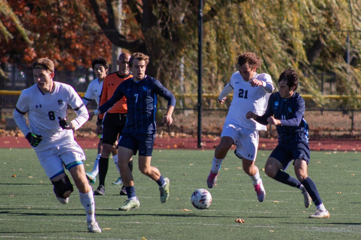 Junior forward Diego Pierantozzi and Roger Williams forward Will Schiffer battling for the ball.