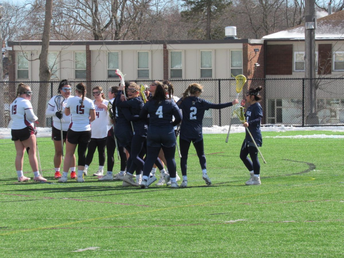 The Lacrosse team celebrates after a goal by Eliza Bryant in the second quarter of a game against Dean College Feb. 22.