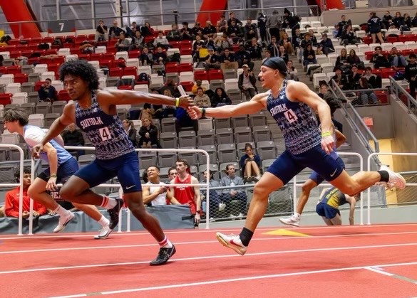 Michael Nossek (right) passes the baton to Ioan Pereira in the 4x400 meter relay during the Suffolk Relays Jan. 11 (courtesy of Michael Nossek).