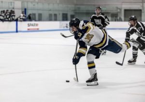 Freshman forward Nolan Leonard shooting the puck during a game against Nichols College Nov. 16 (courtesy of Nolan Leonard).