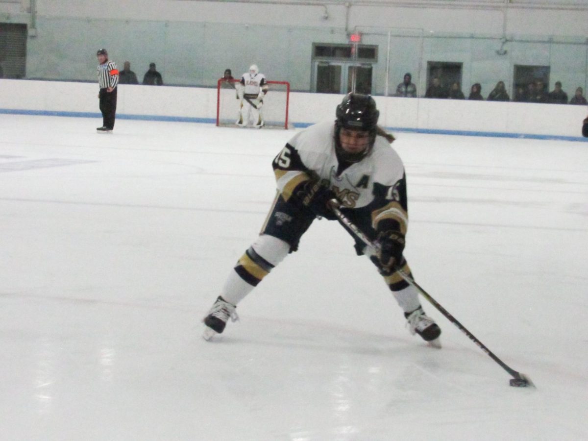 Senior forward Sam Molind shooting the puck during a Jan. 31 game against the University of New England.