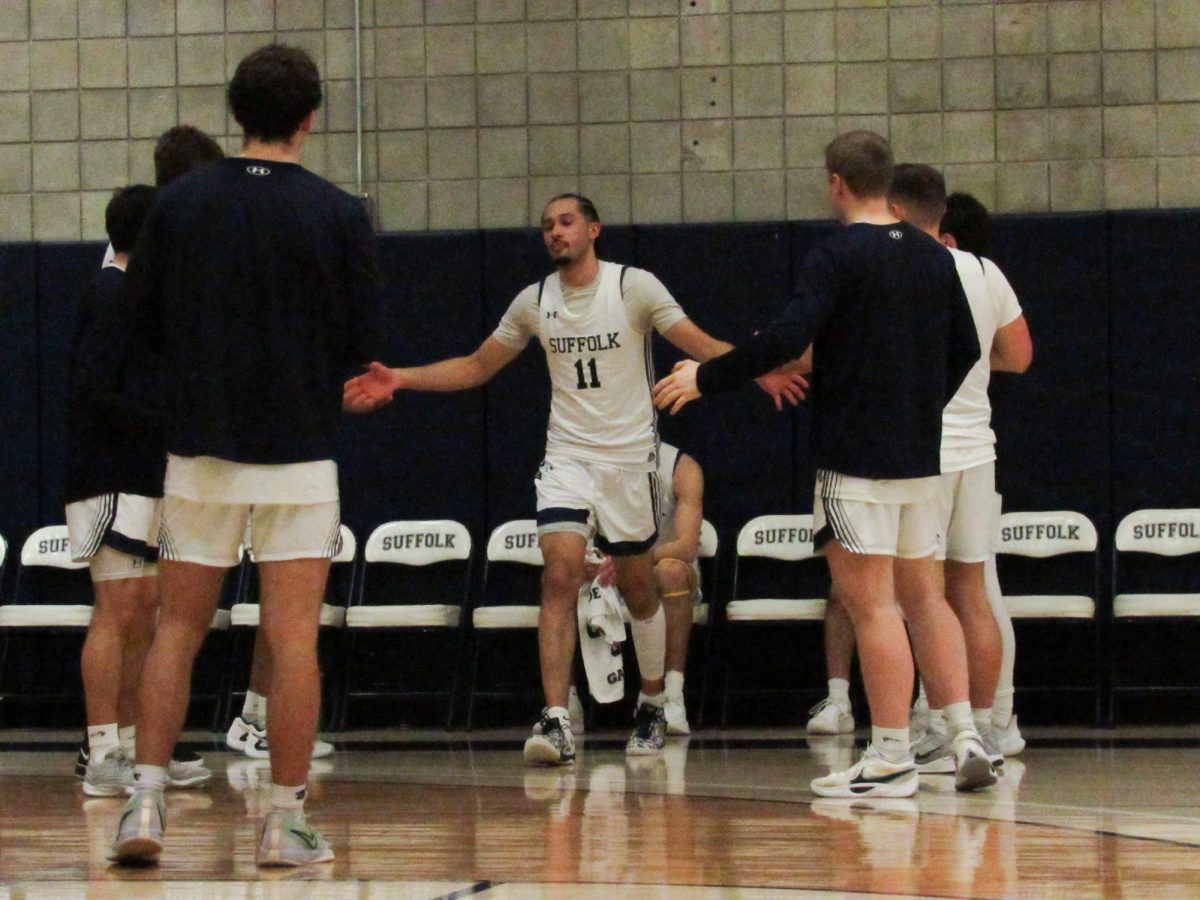 Keenan Robertson high-fiving teammates before a game against the Wentworth Institute of Technology Feb. 25.