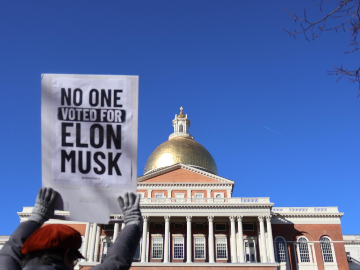 Protestors display signs in front of Massachusetts State House