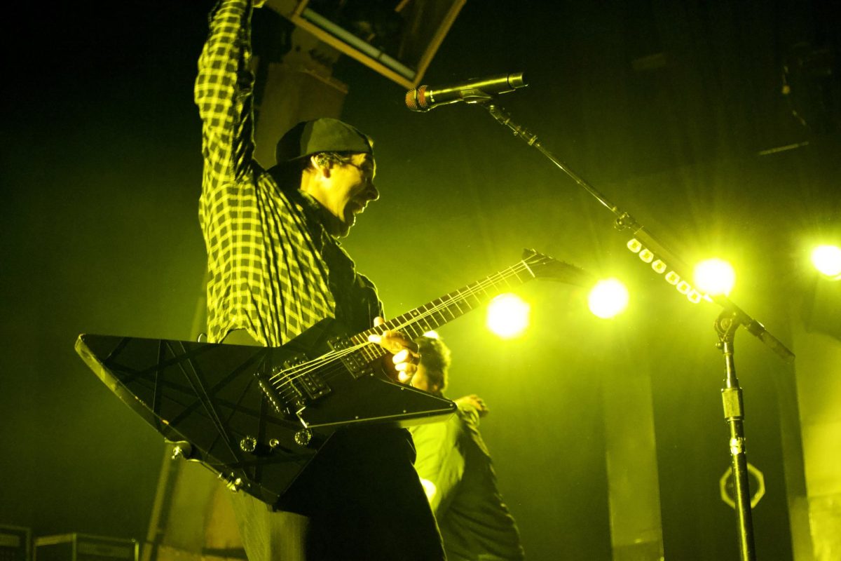 Pierce the Veil's Vic Fuentes rocking out on stage at Xfinity Center. 