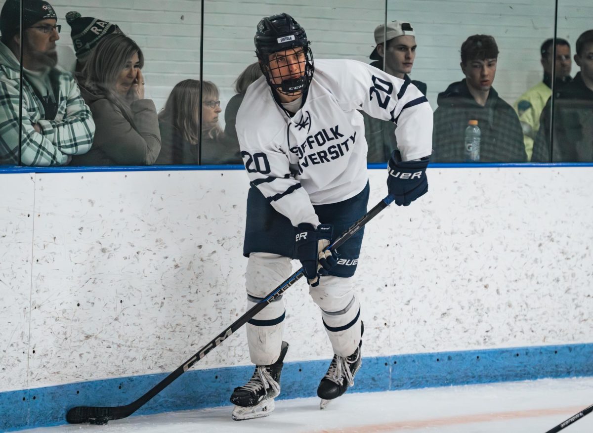 Aidan O'Connell handling the puck along the boards during a playoff game against Johnson & Wales University Feb. 25.