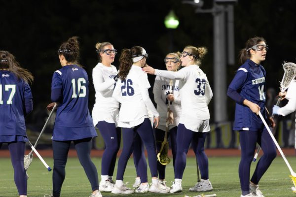 Suffolk Lacrosse celebrating after a goal vs. Endicott College March 25